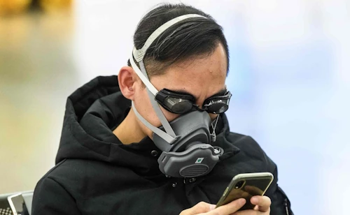 person with mask and smartphone
